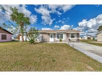 Cute one-story house with a landscaped lawn and driveway at 13540 Dibella Ave, Port Charlotte, FL 33981