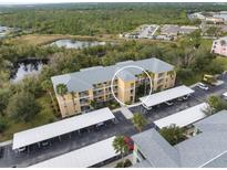 Aerial view of condo community showing building, parking, and landscaping at 2081 Willow Hammock Cir # F204, Punta Gorda, FL 33983
