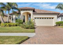 Single-story home with tile roof, two-car garage, and landscaped yard at 2090 Piave Ln, Venice, FL 34292