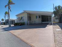 Single-wide manufactured home with carport and palm trees at 657 N Green Cir, Venice, FL 34285
