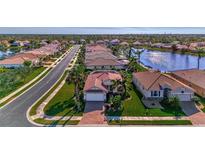 Aerial view of a residential community with houses, streets, and a lake at 11679 Anhinga Ave, Venice, FL 34292