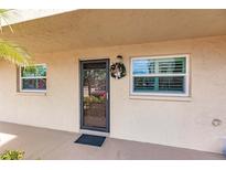 Inviting condo entryway with a wreath and storm door at 2240 Stickney Point Rd # 213, Sarasota, FL 34231