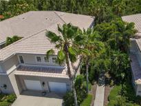 Attractive condo building with lush landscaping and a private walkway at 3000 Ibis Way # 102, Venice, FL 34292