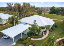 Aerial view of condo with carport, landscaping, and golf course view at 324 Wexford Ter # 171, Venice, FL 34293