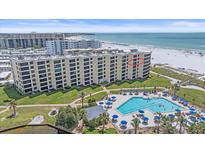 Beautiful beachfront building with a large pool, manicured lawn, and beach access at 5790 Midnight Pass Rd # 602, Sarasota, FL 34242