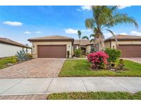 Charming single-story home featuring a brick driveway, mature landscaping, and a well-maintained lawn at 12837 Oriago St, Venice, FL 34293