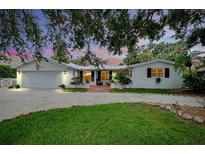 Charming single-story home boasting a brick front patio, white gravel driveway, and lush landscaping at 705 Armada N Rd, Venice, FL 34285