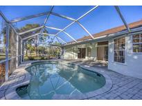 Inviting screened-in pool area with brick-paved deck offers a relaxing outdoor living space at 2899 Ensenada Ln, North Port, FL 34286