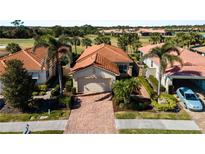 Charming single-story home features a brick driveway, terra cotta roof, and tropical landscaping at 482 Montelluna Dr, North Venice, FL 34275