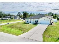 Charming single-story home featuring a manicured lawn and a spacious driveway leading to an attached garage at 8307 Glover Ave, North Port, FL 34291