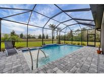Screened-in pool featuring a waterfall feature, tiled flooring, and seating area at 19807 Bridgetown Loop, Venice, FL 34293