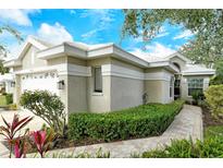 Charming single-story home features a white tile roof and lush landscaping at 560 Fallbrook Dr, Venice, FL 34292