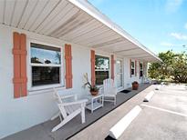 Charming condo featuring a cozy seating area with stylish wooden chairs and coral-colored shutters, inviting relaxation at 1423 Avenida Del Circo # 1C, Venice, FL 34285