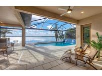Stunning screened-in pool area featuring a waterfall and serene lake views, perfect for outdoor relaxation and entertainment at 400 Maraviya Blvd, Nokomis, FL 34275