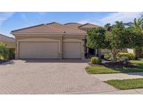 Charming single-story home featuring a tile roof, attached two-car garage, and a beautifully landscaped front yard at 438 Grand Preserve Cv, Bradenton, FL 34212