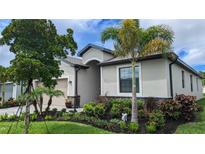 Charming single-story home featuring lush landscaping, a well-manicured lawn, and a welcoming facade at 19716 Fishhawk Trl, Venice, FL 34293