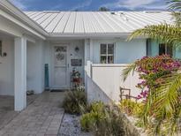 Charming front entrance with white picket fence and lush tropical foliage create inviting curb appeal at 335 Englewood Isles Pkwy # 55, Englewood, FL 34223
