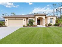 Charming single-story home boasts a manicured lawn, attached two car garage, and lovely landscaping at 1684 Ruiz St, North Port, FL 34286