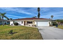 Charming single-story home features a well-maintained lawn and a two-car garage at 1723 N Gondola Ct, Venice, FL 34293