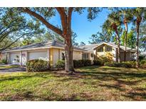 Inviting one-story home featuring a two car garage and mature trees and landscaping at 237 Southampton Ln # 275, Venice, FL 34293