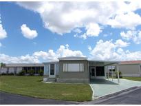 Charming single-story home with carport and green lawn under a partly cloudy sky at 476 Boxwood Dr, Venice, FL 34285