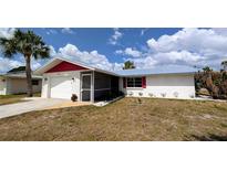 Charming single-story home with a screen door entryway, white exterior, and lush landscaping at 237 Venice East Blvd, Venice, FL 34293