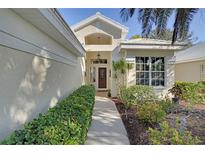 Inviting front entrance with mature landscaping and a charming walkway to the front door at 522 Fallbrook Dr, Venice, FL 34292