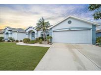 Charming single-story home with a well-maintained lawn, lovely landscaping, and a two-car garage at 5891 Madison Rd, Venice, FL 34293