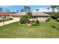 Well-maintained single-story home with a large manicured lawn and lovely landscaping at 407 Rubens Dr, Nokomis, FL 34275