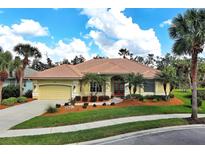 Charming one-story house featuring lush landscaping, a tile roof and a two-car garage at 408 Otter Creek Dr, Venice, FL 34292