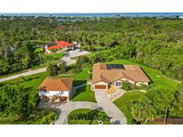 Expansive estate featuring lush landscaping, circular driveway, and bonus building on a verdant lot at 5694 Hale Rd, Venice, FL 34293
