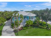 Beautiful two-story home with lush landscaping, covered porches and a metal roof at 746 Eagle Point Dr, Venice, FL 34285