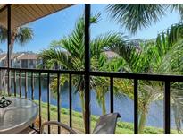 Screened balcony with seating area overlooking lush greenery and water at 630 Bird Bay E Dr # 208, Venice, FL 34285