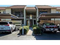 Charming condo exterior features assigned parking, well-maintained landscaping, and inviting stairways to upper units at 630 Bird Bay E Dr # 208, Venice, FL 34285