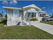 Charming single-Gathering home with a well-manicured lawn and a blue striped awning at 88 Bainbridge Dr # 88, Nokomis, FL 34275