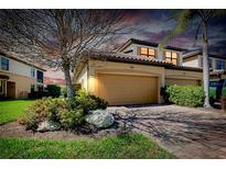 Exterior of two-story home featuring a two-car garage and mature landscaping at 20181 Ragazza Cir # 101, Venice, FL 34293