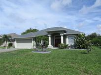 Charming one-story home featuring a two-car garage and well-manicured landscaping at 2115 Pan American Blvd, North Port, FL 34287