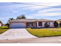 A charming home with a two-car garage, neutral exterior, and a well-maintained lawn at 2221 Bal Harbour Dr, Venice, FL 34293