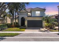 Two-story home featuring a well-maintained lawn, gray facade, tile roof, and attached two-car garage at 23138 Copperleaf Dr, Venice, FL 34293