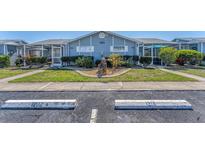 Charming condo exterior with landscaped front yard and assigned parking spaces for easy access at 3300 Loveland Blvd # 1201, Punta Gorda, FL 33980