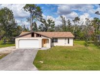 Charming single-story home with a garage, cream-colored paint, and a spacious front yard at 3716 Dunbar Rd, Venice, FL 34293