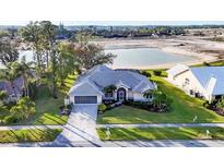 Charming home with well-manicured lawn, mature trees, and beautiful lake view at 5051 Greenway Dr, North Port, FL 34287