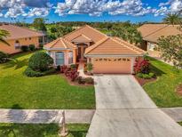 Beautiful single-story home with tile roof, manicured lawn, and two-car garage at 5151 Pine Shadow Ln, North Port, FL 34287