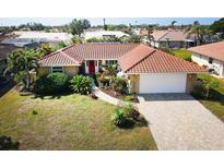 Charming home with a red door, red tile roof, and a two car garage at 9 Windsor Dr, Englewood, FL 34223