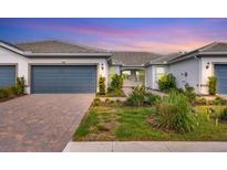 Charming single-story home with a neatly landscaped front yard and a two-car garage at 9916 Bright Water Dr, Englewood, FL 34223