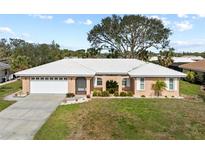 Charming single-story home with a well-manicured front lawn, two-car garage, and white roof at 107 Corot Dr, Nokomis, FL 34275