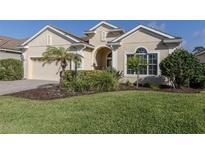 Inviting front exterior showcasing lush landscaping, a well-maintained lawn, and a charming single-story home at 10768 Trophy Dr, Englewood, FL 34223