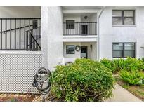 Exterior view of a two-story condo featuring a well-maintained yard and a covered entry at 1100 Capri Isles Blvd # 422, Venice, FL 34293