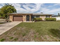 Charming single-story home featuring a stone facade, well-maintained lawn, and inviting curb appeal at 1200 Yawl Way, Venice, FL 34285