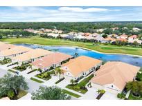 Beautiful aerial view of homes with tile roofs and lush landscaping near a golf course and scenic pond at 1697 San Silvestro Dr, Venice, FL 34285